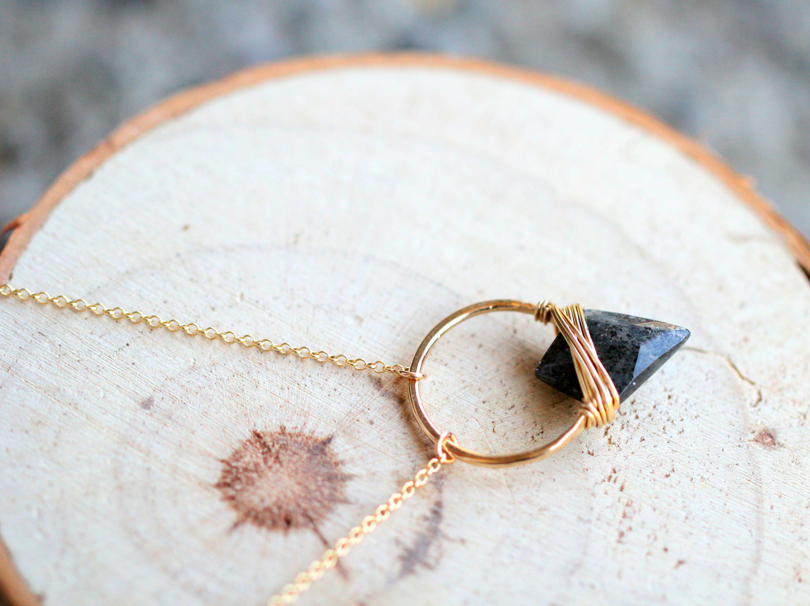 Gold pendant necklace with black sunstone arrowhead triangle pendant. Wire Wrapped Gemstone Jewelry