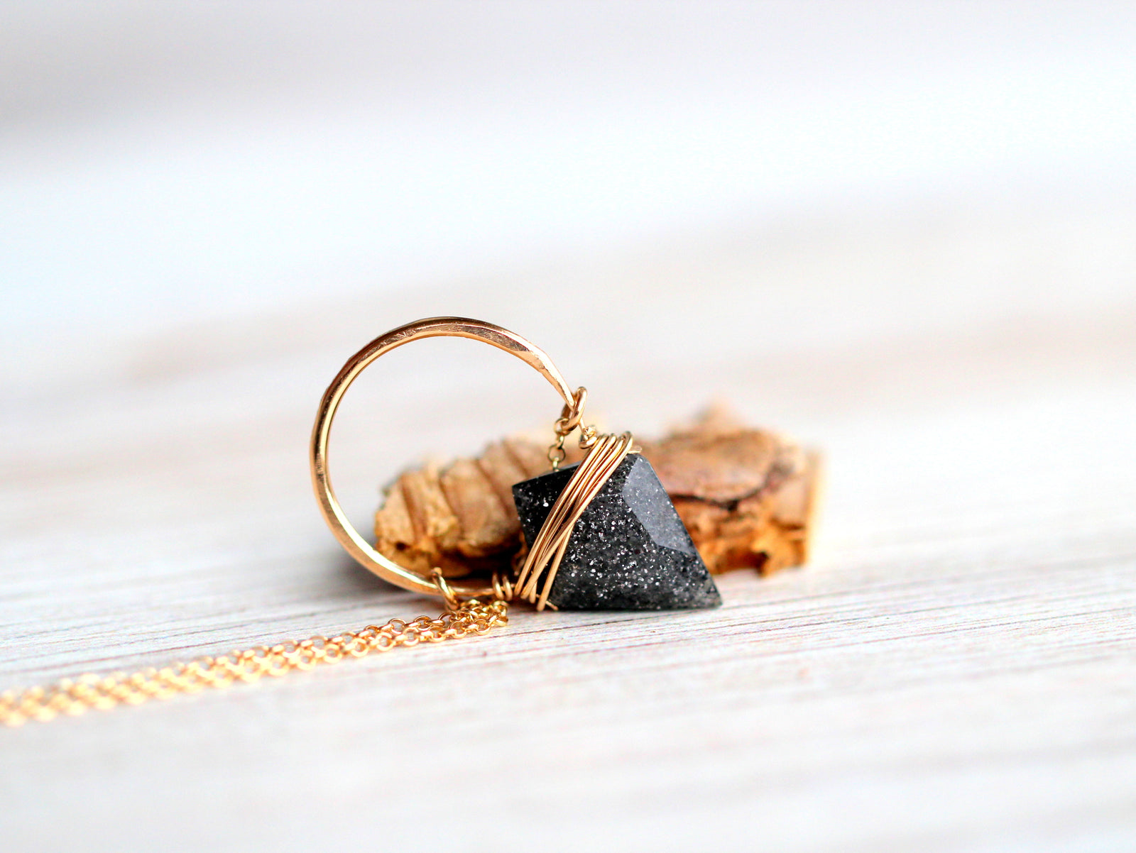 Gold pendant necklace with black sunstone arrowhead triangle pendant. Wire Wrapped Gemstone Jewelry